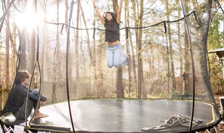 Two people enjoying a trampoline towards the end of summer.