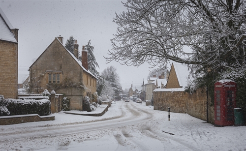 A wintery scene with snowed-up roads and houses.