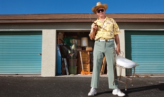 A man at his storage unit holding a chair