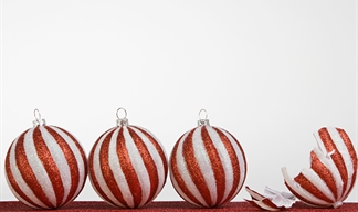 Decorative: A row of striped Christmas baubles, one of which is broken -- to suggest a stressful festive situation.